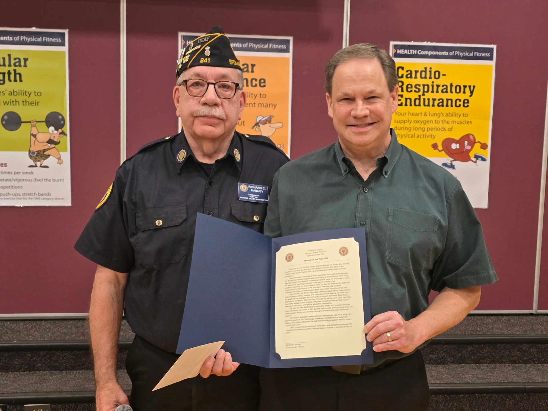 Commander Richard C. Hamley of American Legion Post 241 presents the 2026 Teacher of the Year citation to Andrew Phillips